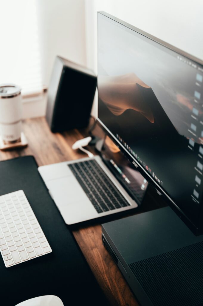 Photo by Max Andrey on Unsplash Image demonstrating website design services by Iron and Ember Studios. MacBook is open on desk showing a wallpaper.